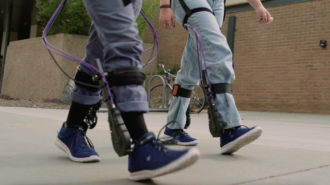 two people walking wearing the Biomotum SPARK device.
