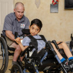 a man and child both sitting in a wheelchair.